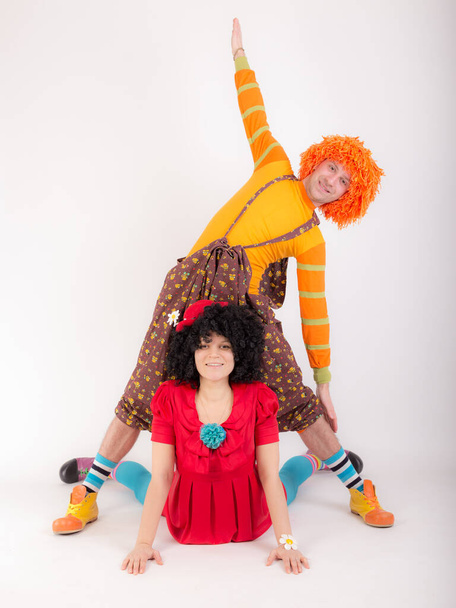 studio portrait of a couple in clown costumes doing yoga - Zdjęcie, obraz