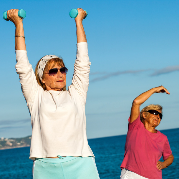 Seniorinnen machen Fitnessübungen am Strand. - Foto, Bild