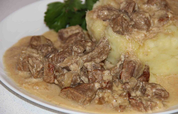 Carne di manzo Stroganoff con purè di patate su un piatto bianco
 - Foto, immagini