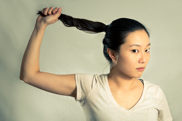 genç bir kadın saçlarını çekerek - Fotoğraf, Görsel