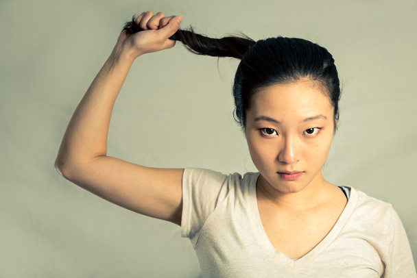 Nuori nainen vetää hänen hiukset
 - Valokuva, kuva