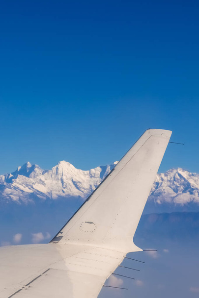 Wings of an airplane against the majestic himalaya mountains - 写真・画像