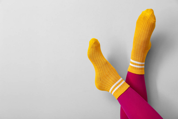 Πόδια νεαρής γυναίκας με κάλτσες και καλσόν σε ανοιχτό φόντο - Φωτογραφία, εικόνα