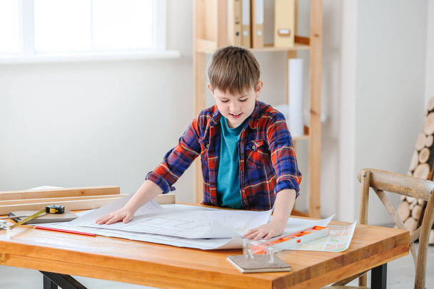 Cute little builder with drawings in room - Foto, Imagem