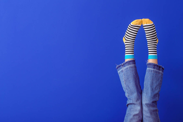 Legs of young woman in striped socks on color background - Fotografie, Obrázek
