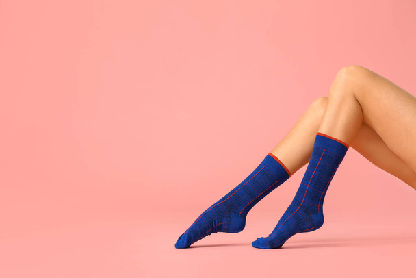 Legs of young woman in socks on color background - Фото, зображення