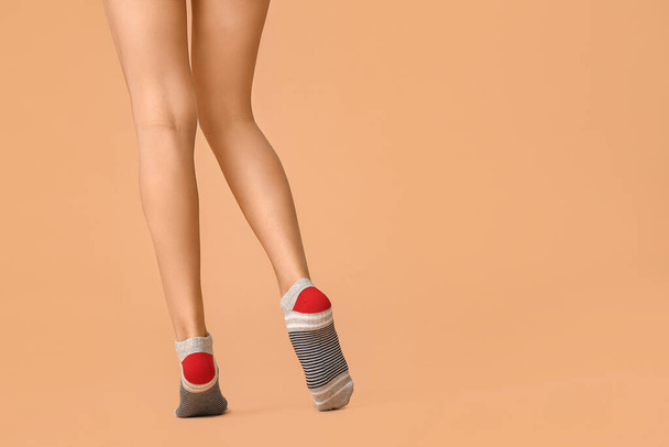 Legs of young woman in socks on color background - Foto, afbeelding