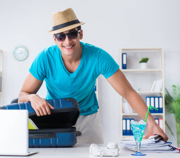 Businessman preparing for vacation in the office - Photo, image