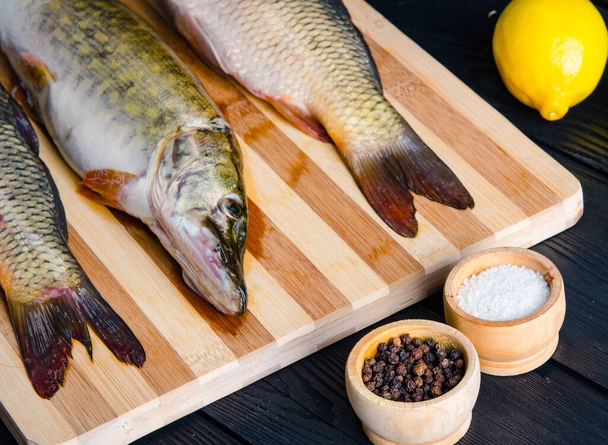 ongekookte vis op snijplank in maaltijdbereidingsconcept - Foto, afbeelding