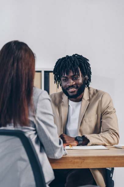 Enfoque selectivo del reclutador afroamericano que realiza una entrevista de trabajo con un empleado en la oficina
 - Foto, imagen