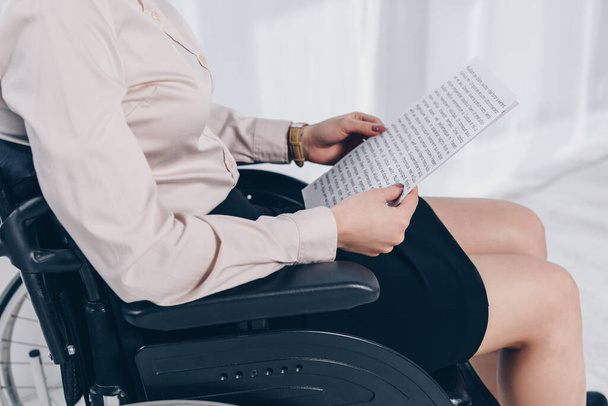 Cropped view of disabled recruiter with papers on wheelchair in office - Zdjęcie, obraz
