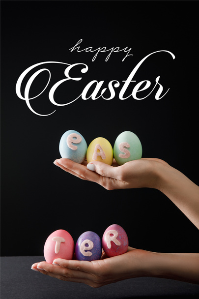 Selektivní zaměření velikonočních vajec na dřevěnou tabuli na černou s veselou velikonoční ilustrací - Fotografie, Obrázek