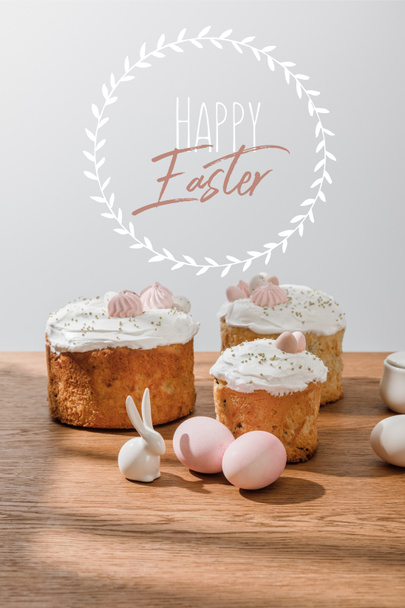 Декоративный кролик, куриные яйца, сахарная чаша с пасхальными тортами, изолированными на сером с счастливой пасхальной иллюстрацией
 - Фото, изображение