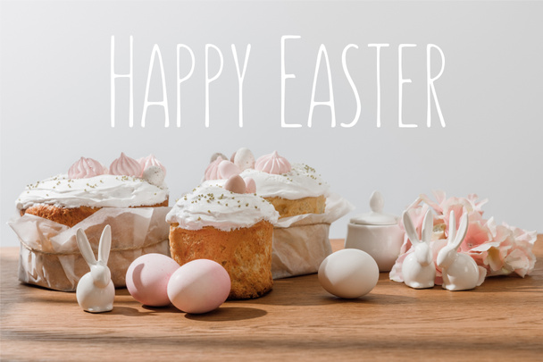Decorative bunnies, chicken eggs, sugar bowl, Easter cakes and petals isolated on grey with happy Easter illustration - 写真・画像