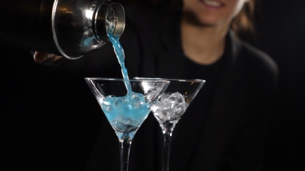 Cantinera preparando cóctel azul brillante vertiendo líquido de la coctelera. Hacer cóctel alcohólico con hielo. Camarera haciendo cóctel en cámara lenta. Full hd
 - Metraje, vídeo