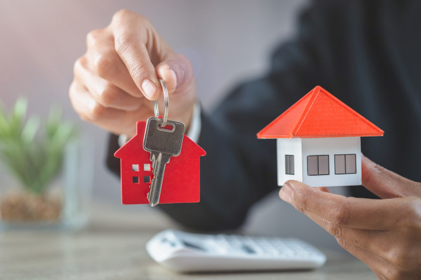 Agent nieruchomości gospodarstwa dom model i klucze, klient podpisujący kontrakt na zakup domu, ubezpieczenia lub pożyczki nieruchomości. - Zdjęcie, obraz