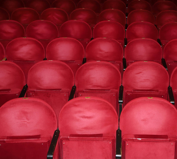Κλασικές σειρές κενών κοκκινωπών καθισμάτων στο θέατρο. Αίθουσα χωρίς επισκέπτες. Ρηχό βάθος πεδίου - Φωτογραφία, εικόνα