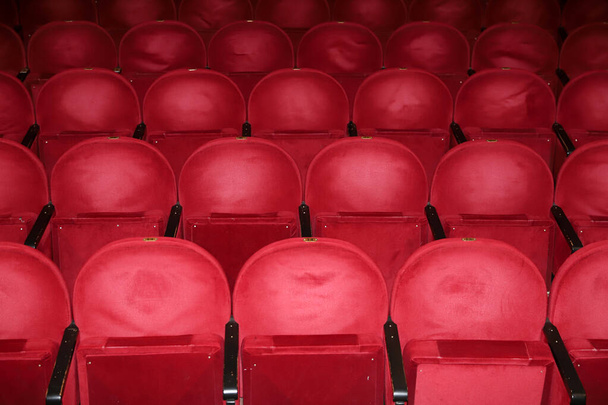 Klassieke rijen lege roodachtige stoelen in het theater. Zaal zonder bezoekers. Ondiepe scherptediepte - Foto, afbeelding