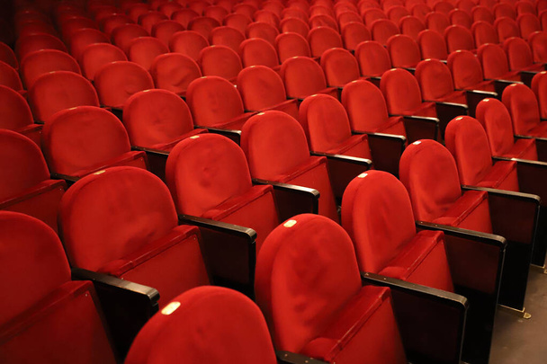 Klassische Reihen leerer rötlicher Sitze im Theater. Halle ohne Besucher. Geringe Tiefenschärfe - Foto, Bild
