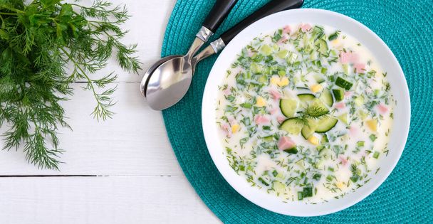 Cold summer soup okroshka. Light soup in a white bowl. Top view. - Foto, immagini