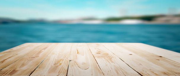 Dřevěný prázdný povrch na bokeh modré moře pozadí v odpoledních hodinách. - Fotografie, Obrázek