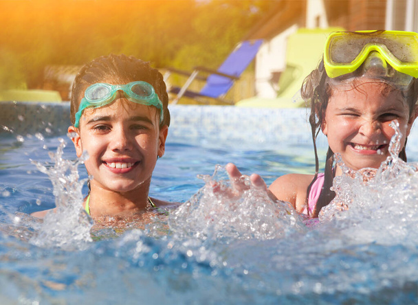 Yüzme havuzunda oynayan iki sevimli kız. Yaz tatil ve seyahat kavramı - Fotoğraf, Görsel