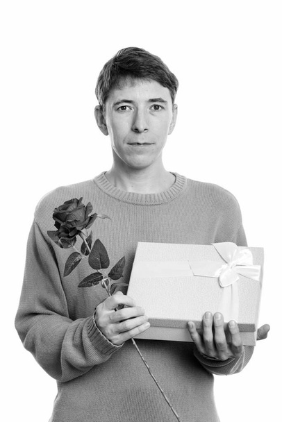 Studio shot of man wearing sweater isolated against white background in black and white - 写真・画像