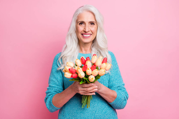 Portrait of charming lovely pretty granny hold bunch with colorful tulips she get from her husband on 14-february celebration wear casual style sweater isolated over pastel color background - Фото, изображение