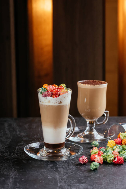 tasses en verre cappuccino avec des bonbons colorés sur fond de table
 - Photo, image