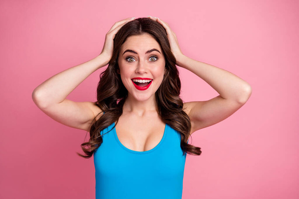 Closeup photo of pretty crazy curly lady open mouth arms on head listen shocking good news unexpected success wear casual blue singlet isolated pink bright color background - Zdjęcie, obraz
