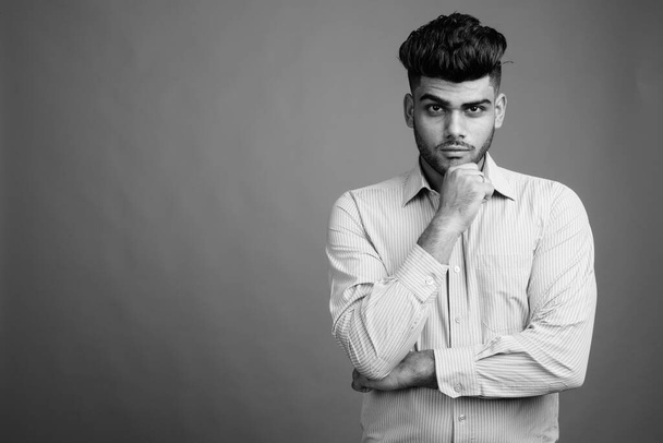 Studio záběr mladý hezký indický podnikatel proti šedé pozadí v černé a bílé - Fotografie, Obrázek