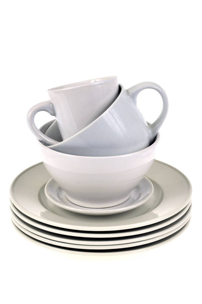 Тарелки, чашки и миски сложены крупным планом на белом фоне
 - Фото, изображение