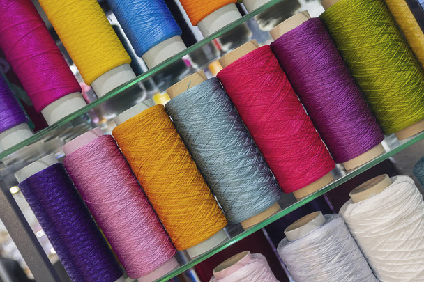 Dikiş için çok renkli iplikleri ile Bobinler. Kumaş ve tekstil endüstrisi - Fotoğraf, Görsel