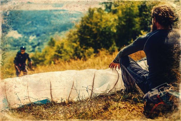 Paragliding in the mountains, paraglider on the ground, old photo effect - Photo, Image