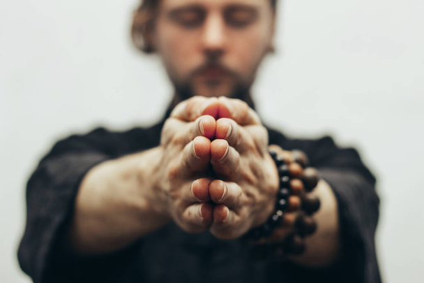 Fingers pointing forward to the camera. Hands folded in prayer. Close-up of palm together. The beads on the wrist. The rosary on hand. - Photo, Image