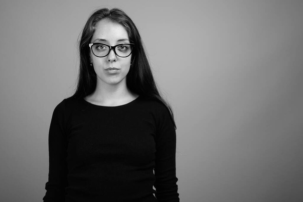 Estúdio tiro de jovem bela mulher contra fundo cinza em preto e branco
 - Foto, Imagem
