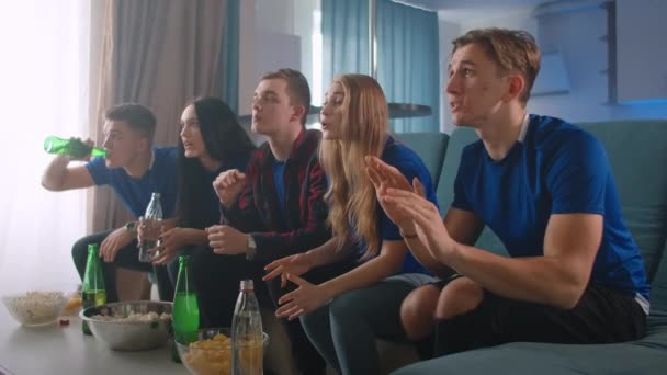 Vijf vrienden kijken naar de Olympische Spelen op TV terwijl ze thuis zitten en het emotioneel vieren. de vreugde van het winnen en winnen van het kampioenschap. - Video