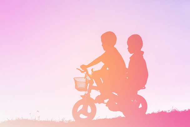 két kisfiú bicikli sziluett - Fotó, kép