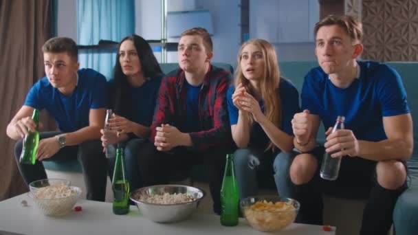 A group of friends celebrate together the victory of their favorite team. Watch the broadcast and follow the competition. - Materiał filmowy, wideo