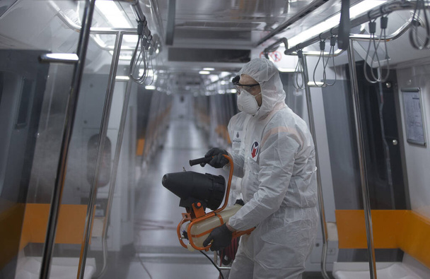 Стамбул, Турция, 12 марта 2020 года, Участники Стамбульского метрополитена дезинфицируют поезд в связи с эпидемией коронавируса (COVID-19) во всем мире
. - Фото, изображение
