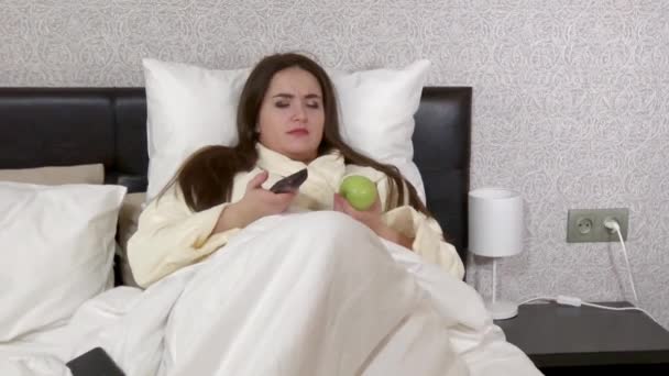 Plus size young woman lying in bed, talking by phone - Video