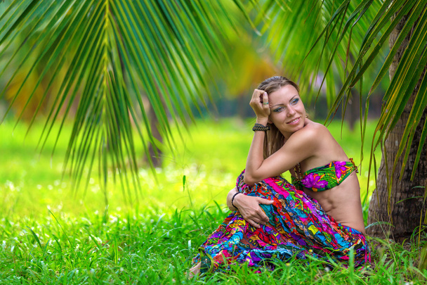 mooi meisje onder een palmboom - Foto, afbeelding