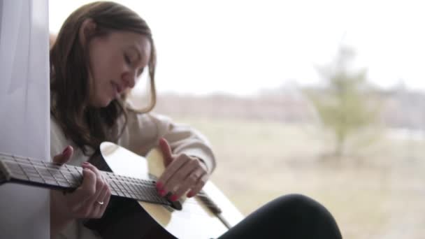 Красивая женщина играет на гитаре
 - Кадры, видео