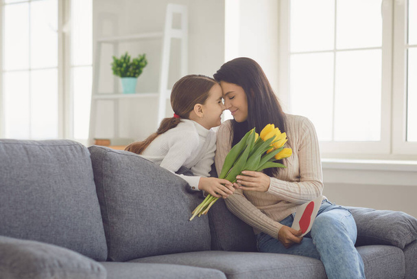 Happy mothers day. Daughter congratulates hugs his mother holds a bouquet of flowers in the room. - Zdjęcie, obraz