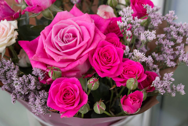 Gift bouquet with pink roses and decorative plants. - Foto, afbeelding