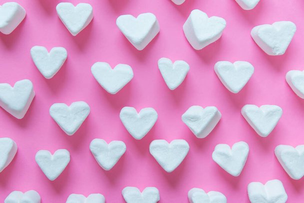 Pattern made with heart shaped white sweet marshmallows on pink background. 3d illustration. - Photo, image