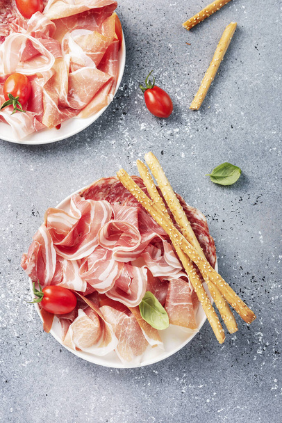 traditional italian antipasto with ham, salami and bread sticks, selective focus image - Foto, Bild