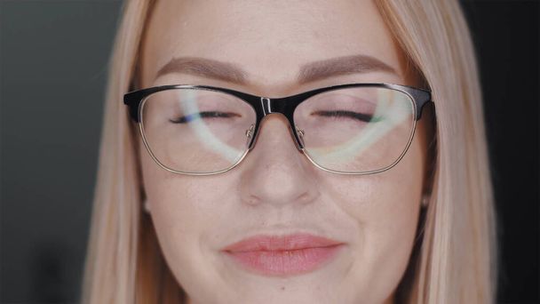Portrait of independent successful young business woman in glasses with beautiful white hair, clear skin and plump lips. Positive feminine background concept. Slow motion close up front view 4K video. - 写真・画像