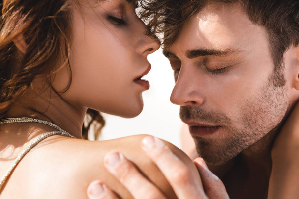 passionné sexy jeune couple embrasser avec les yeux fermés sur la plage
  - Photo, image