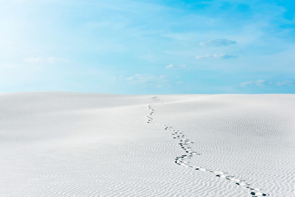 красивий пляж зі слідами на білому піску і блакитному небі з білими хмарами
 - Фото, зображення